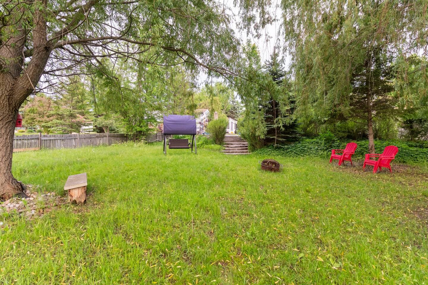 Large private lawn with a swing and fire pit seating